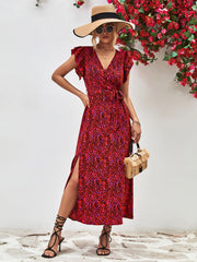 Red printed slit dress shown on a model with one hand at the waist.
