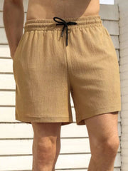 Model wearing tan drawstring shorts, front view