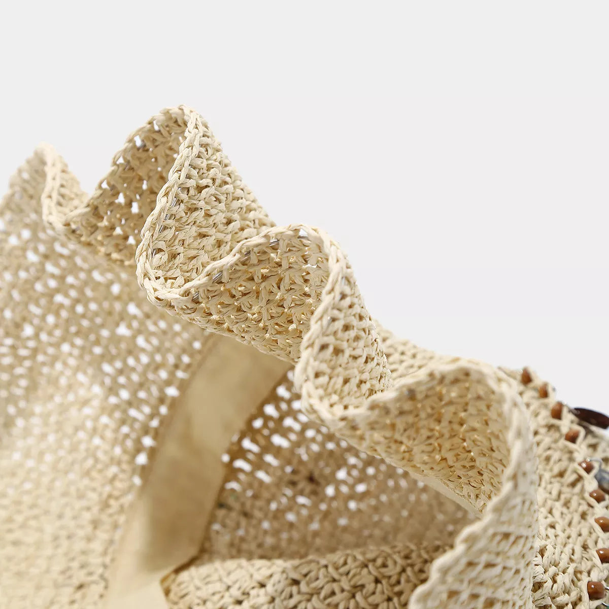Close-up of the open woven straw pattern and wavy brim