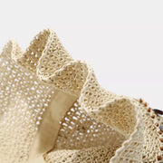 Close-up of the open woven straw pattern and wavy brim