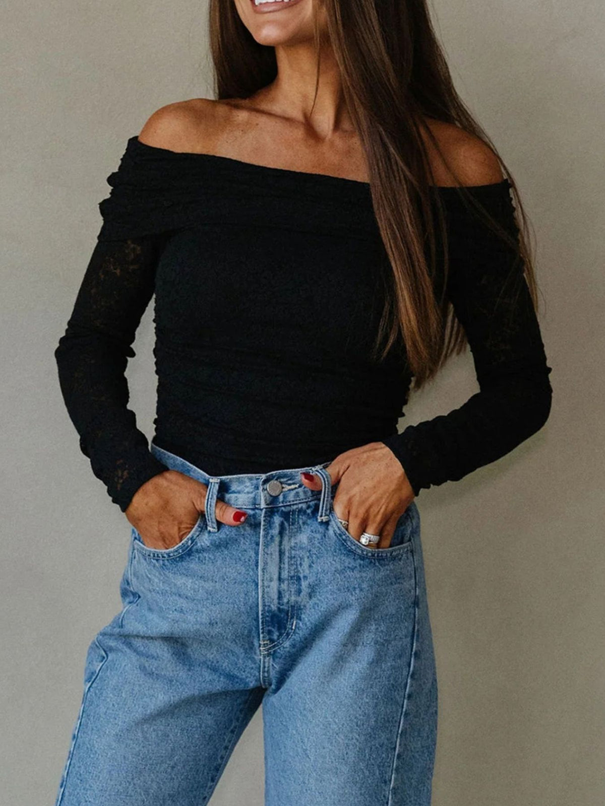 Model wearing black off-shoulder long-sleeve top