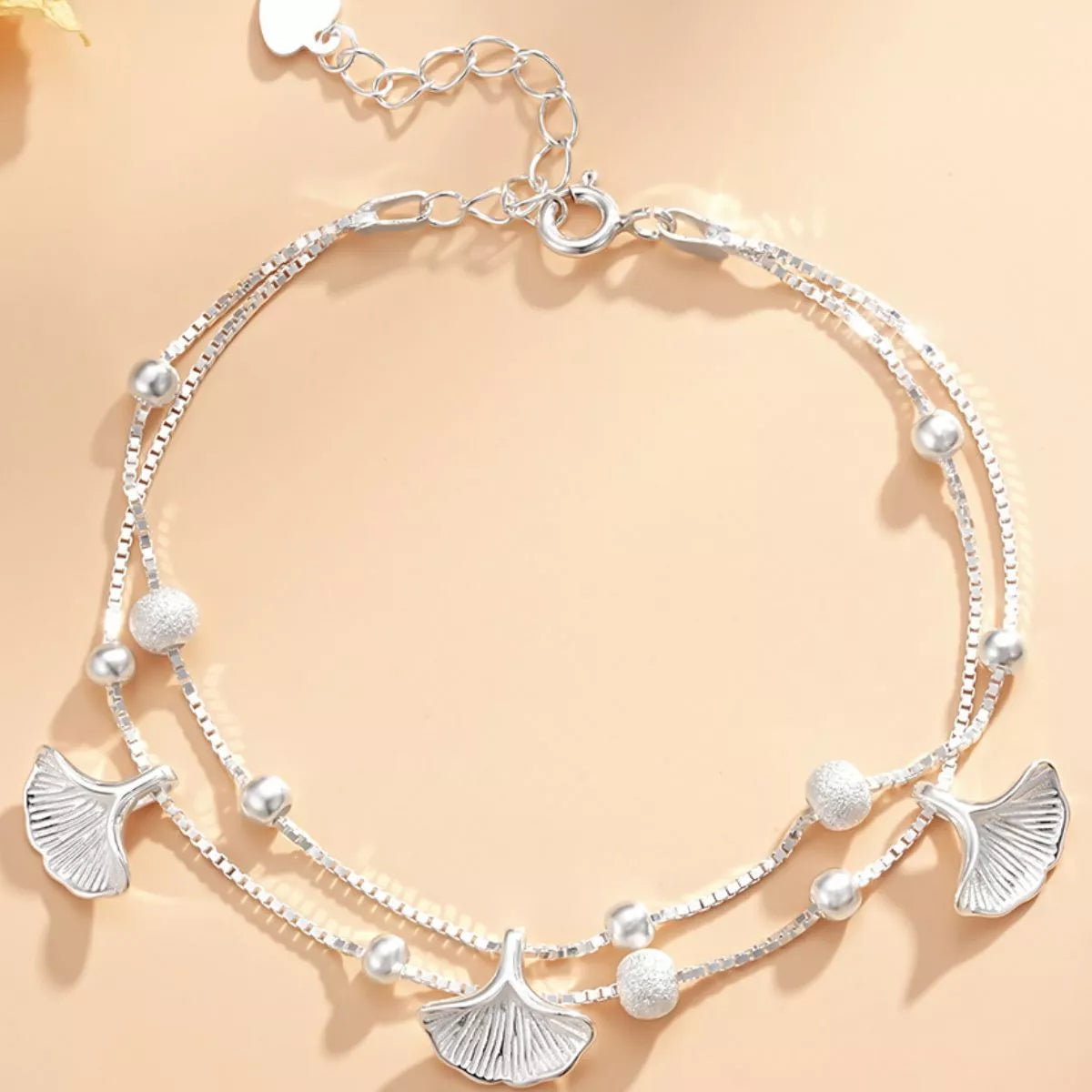 Overhead view of the double-layer ginkgo leaf bracelet with extension chain