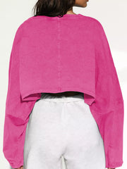 Back view of the pink cropped sweatshirt with roomy long sleeves