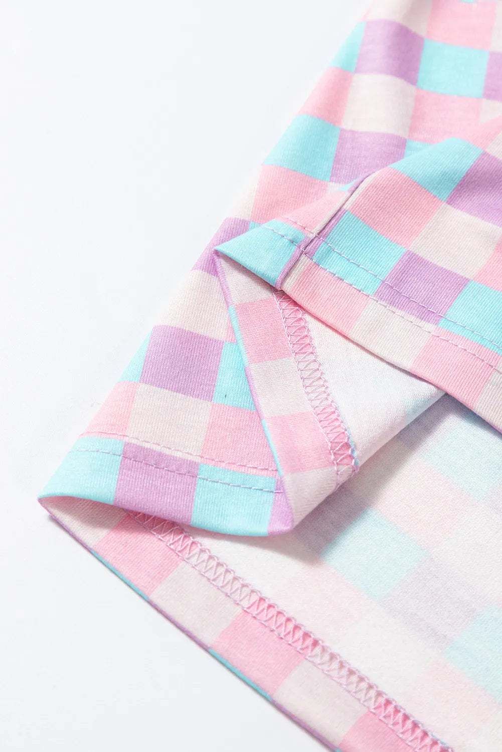 Close-up of pink and blue checked shirt sleeve and white cuff trim