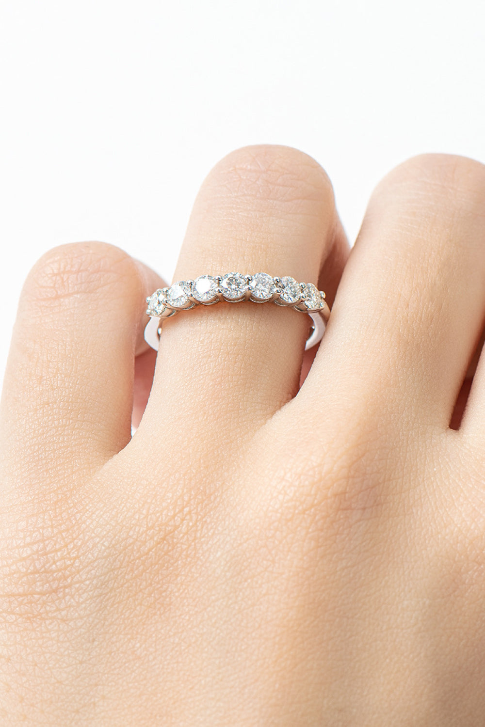 Close-up of a silver-tone ring with a row of round clear stones worn on a finger