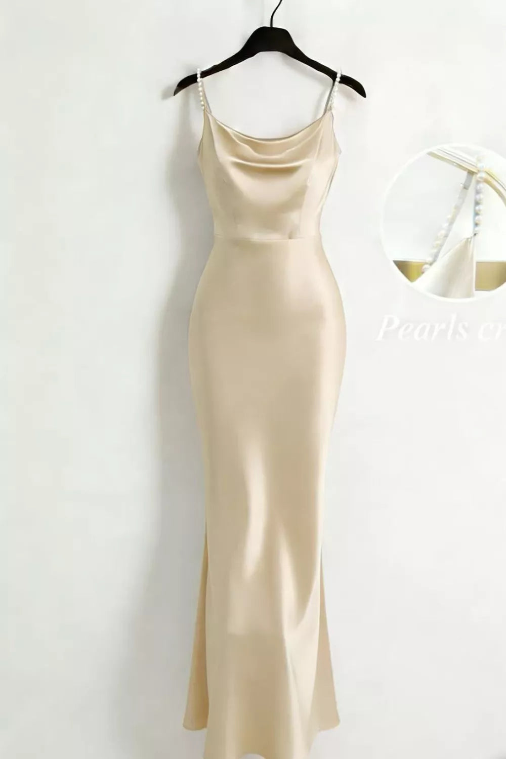 Cream satin cowl-neck maxi dress with pearl straps on a hanger.