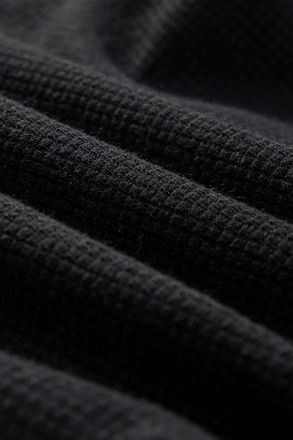 Close-up of black textured jumpsuit fabric weave