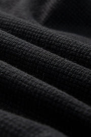 Close-up of black textured jumpsuit fabric weave
