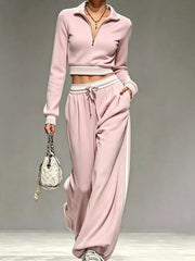 Model in pink half-zip cropped top and matching wide-leg pants, full view