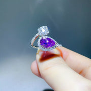 Side angle of the purple teardrop moissanite ring showing its curved silver band