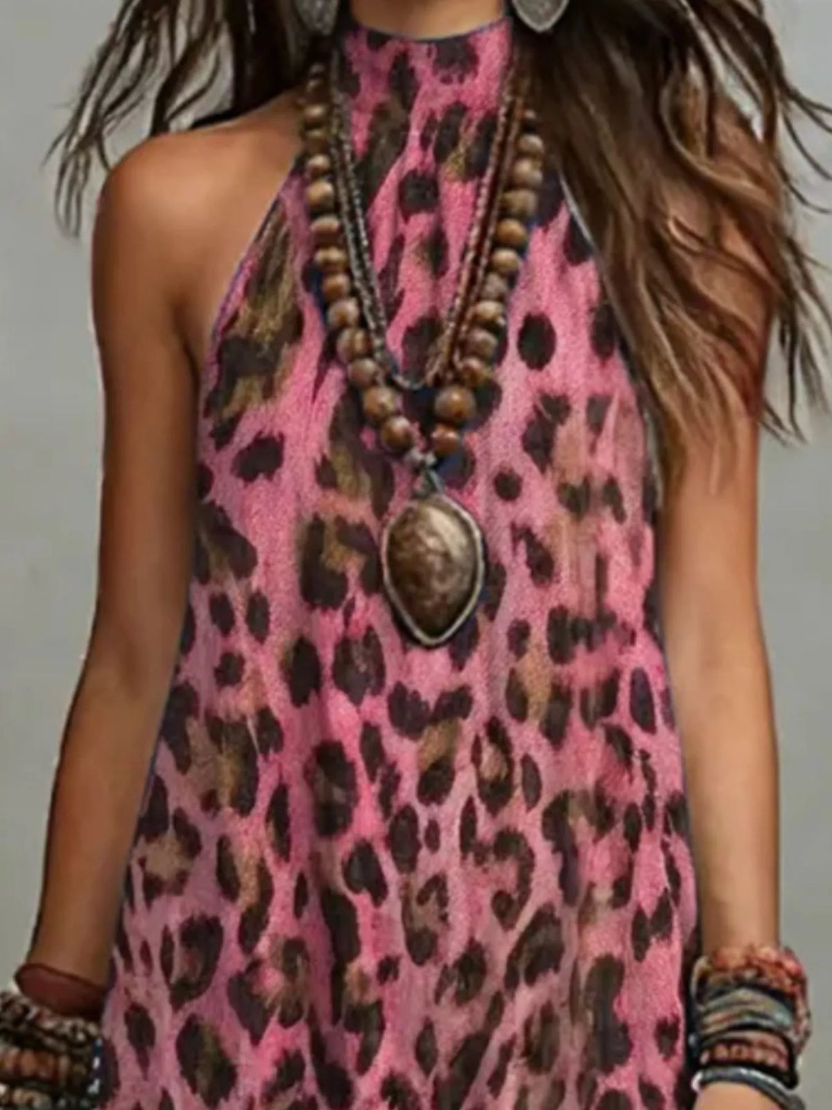 Close-up of the pink leopard-print dress's high halter neckline and sleeveless armhole.