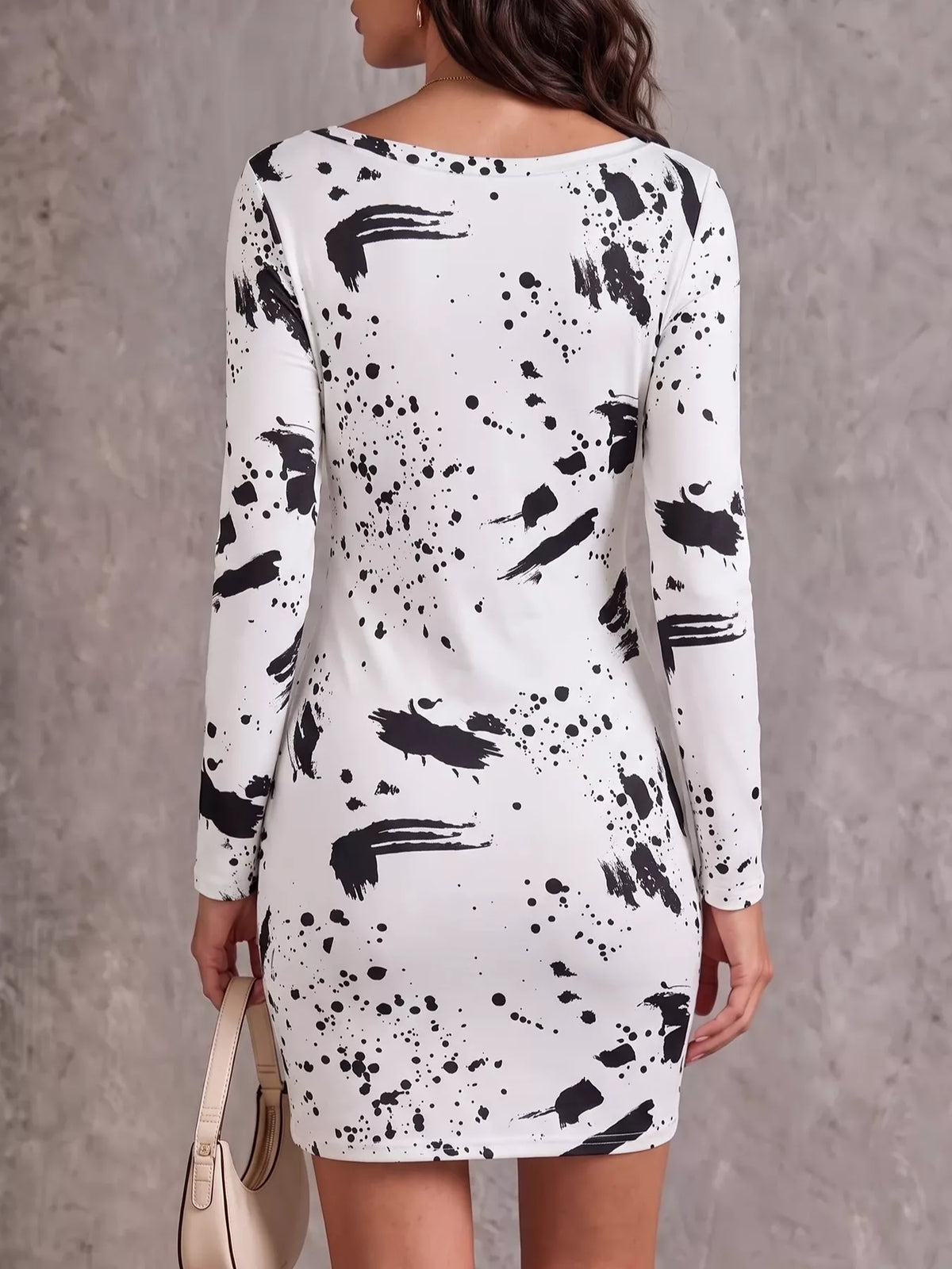 Back view of white long-sleeve mini dress with black paint-splatter pattern