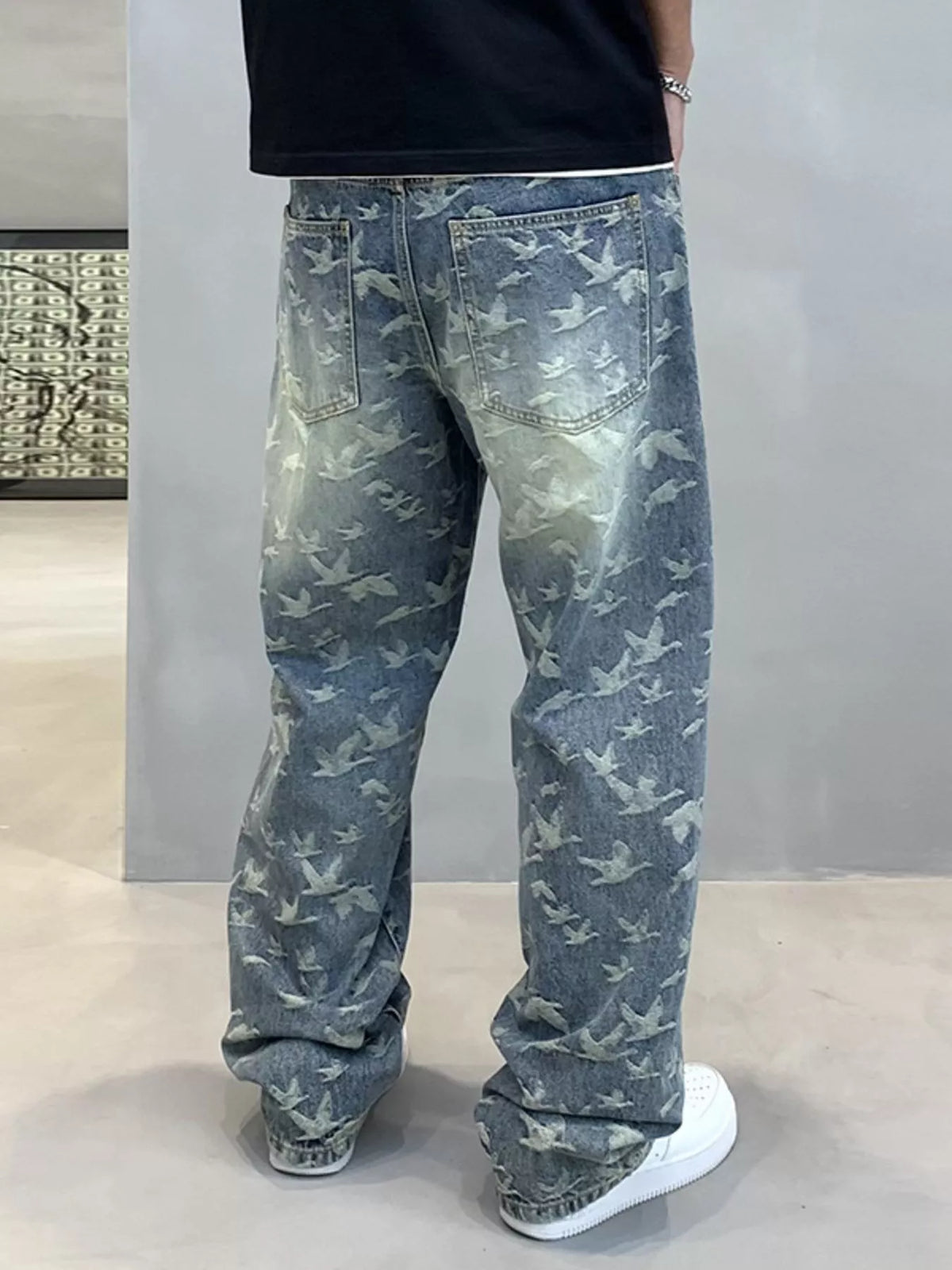 Full back view of loose blue jeans with an all-over flying-bird pattern