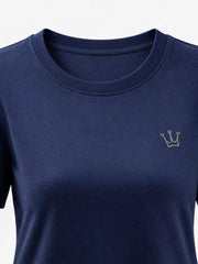 Close-up of navy T-shirt crew neckline and small crown emblem.