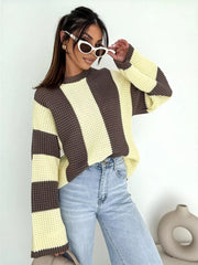 Model standing in cream and brown striped oversized sweater and jeans