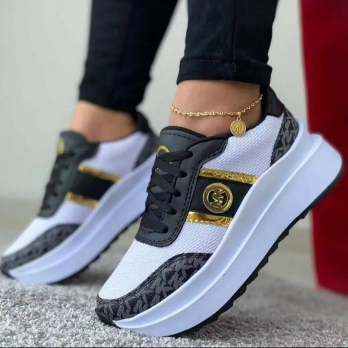 White and black mesh platform sneakers with gold accents, side view