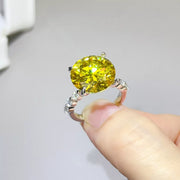 Side view of yellow round stone and silver setting held in hand
