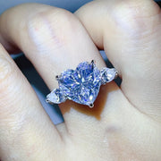 Clear heart centre stone ring worn on a hand.