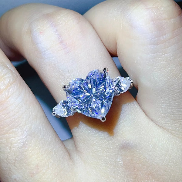 Clear heart centre stone ring worn on a hand.