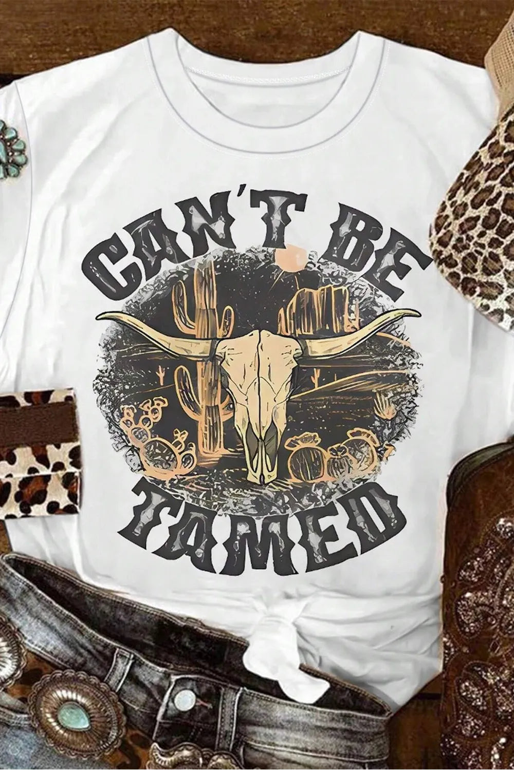 Close-up of Cant Be Tamed graphic on white T-shirt