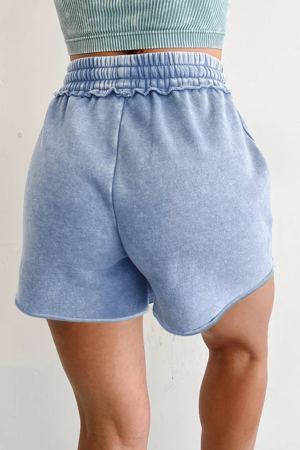 Model wearing light-blue drawstring shorts, back view