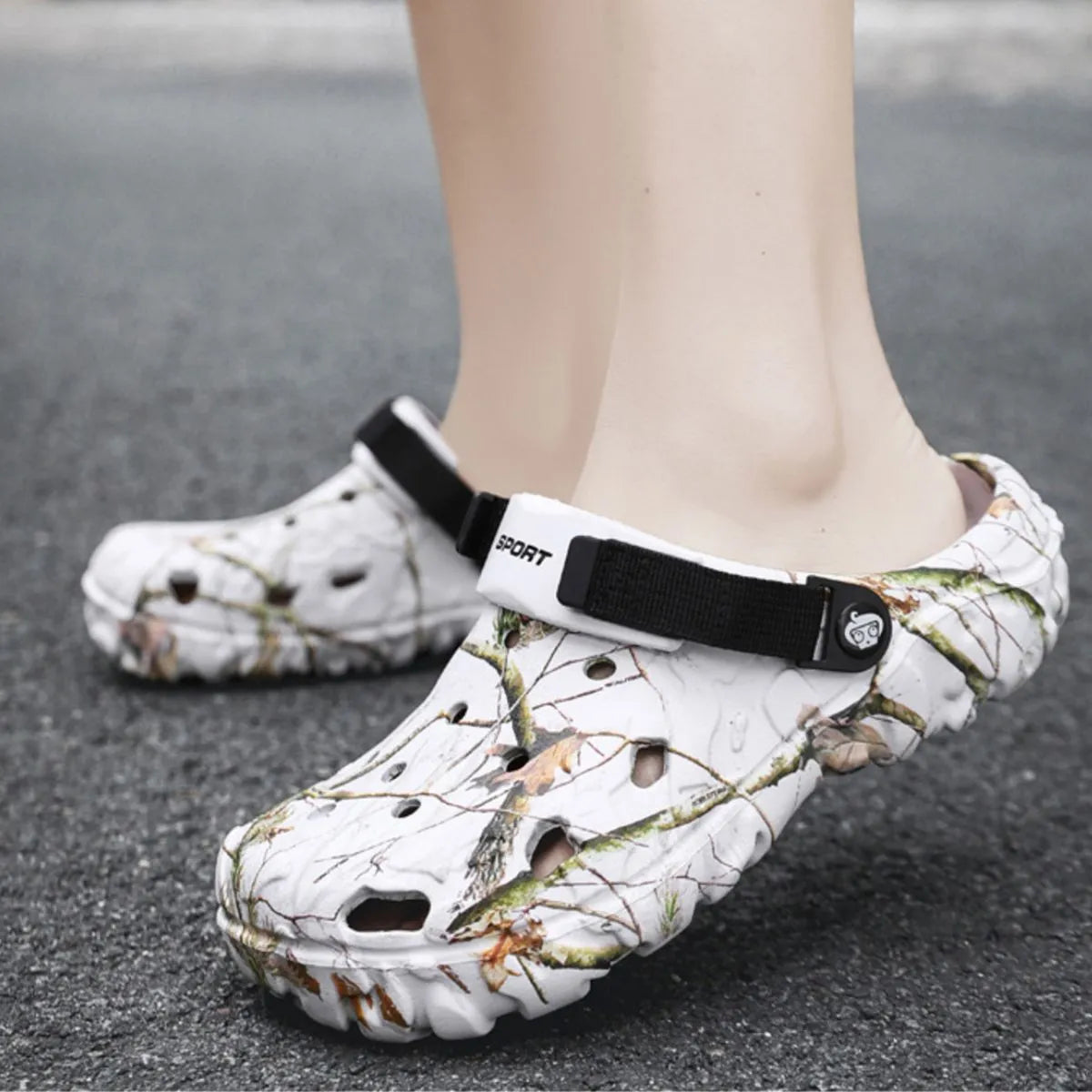 White branch-print clogs with black straps worn outdoors