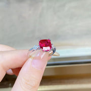 Red rectangular zircon ring shown on a hand.