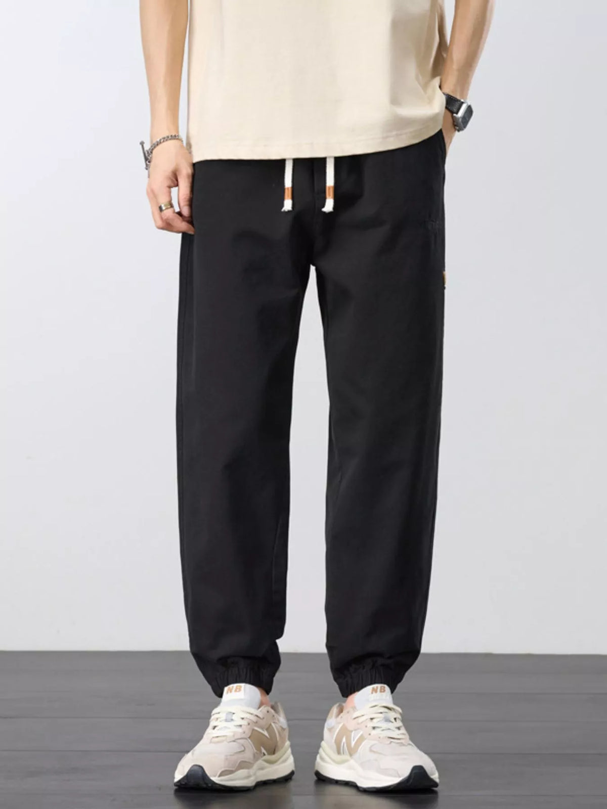 Front view of black joggers with drawstring waist and elastic ankle cuffs.