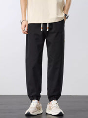 Front view of black joggers with drawstring waist and elastic ankle cuffs.