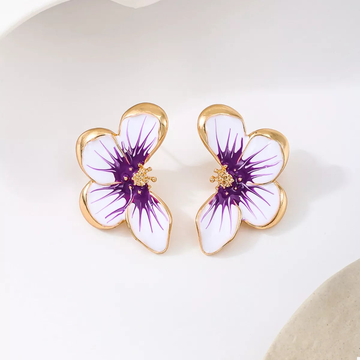 Pair of purple-and-white flower stud earrings, front view