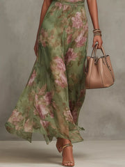 Close view of the flowing floral-print skirt and waist of the maxi dress.