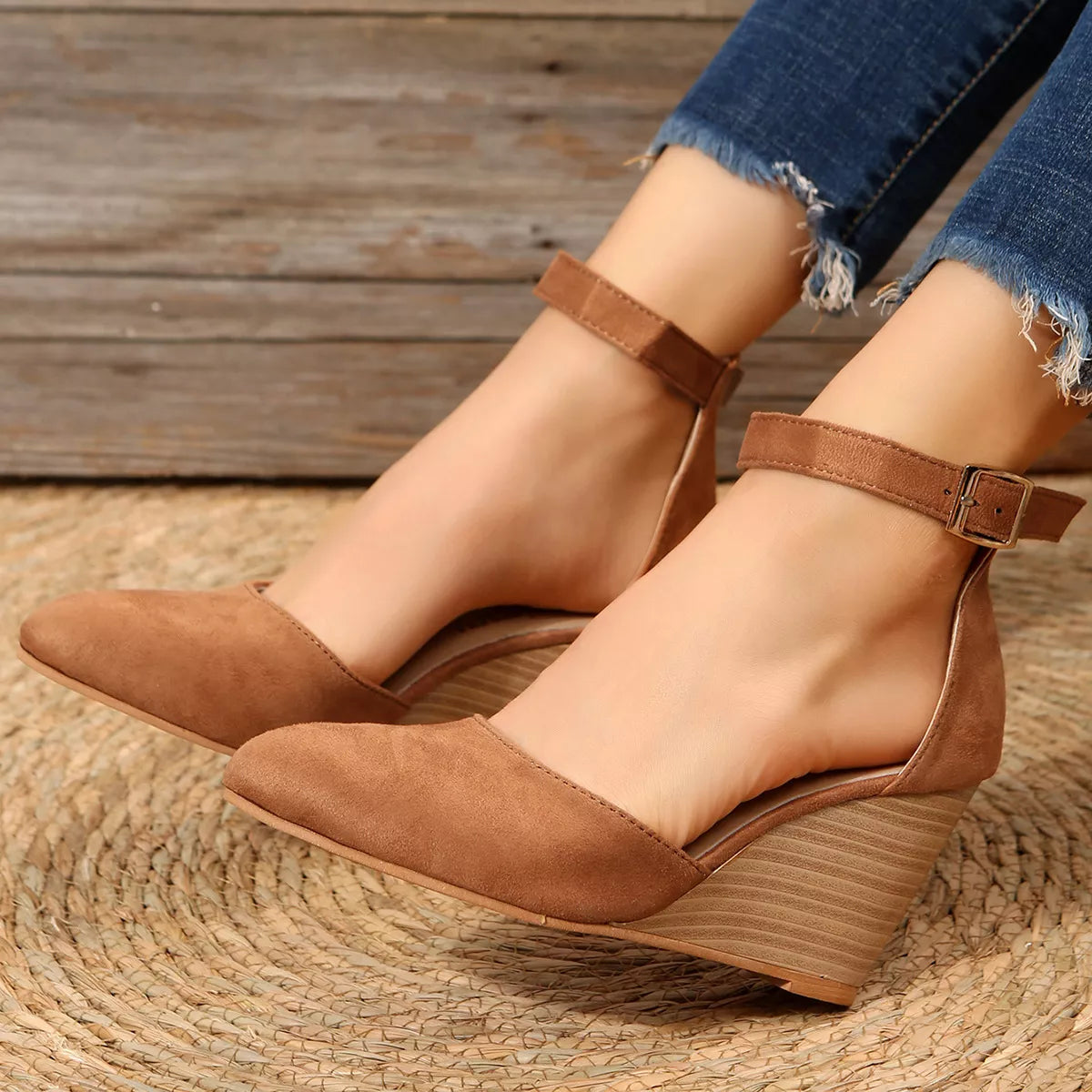Tan pointed-toe wedge sandals shown from the side on feet