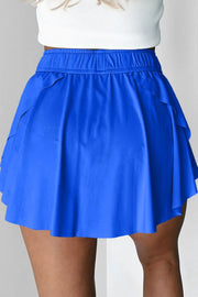Back view of blue skort worn with flared skirt and elastic waistband