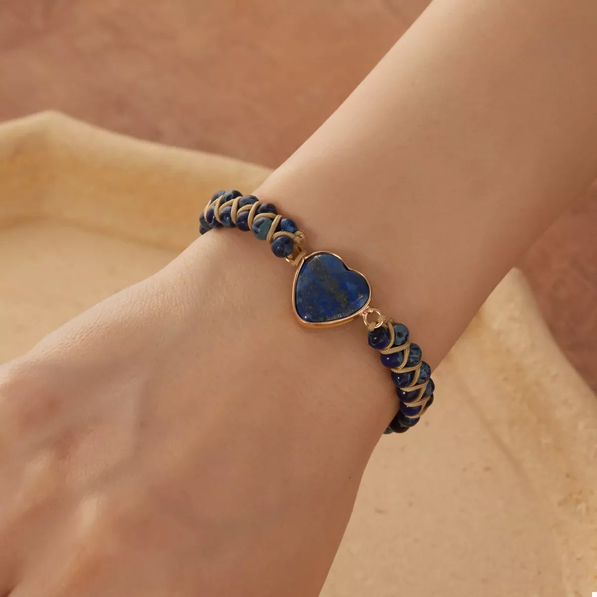 Navy beaded bracelet with a blue heart centerpiece worn on a wrist.