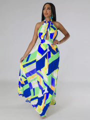 Blue and lime halter maxi dress on a model with one hand on her hip and the skirt fanned outward.