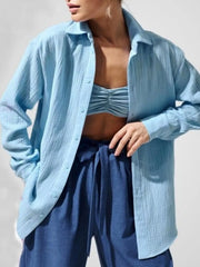 Model wearing a light blue gauze button-down over a blue top.