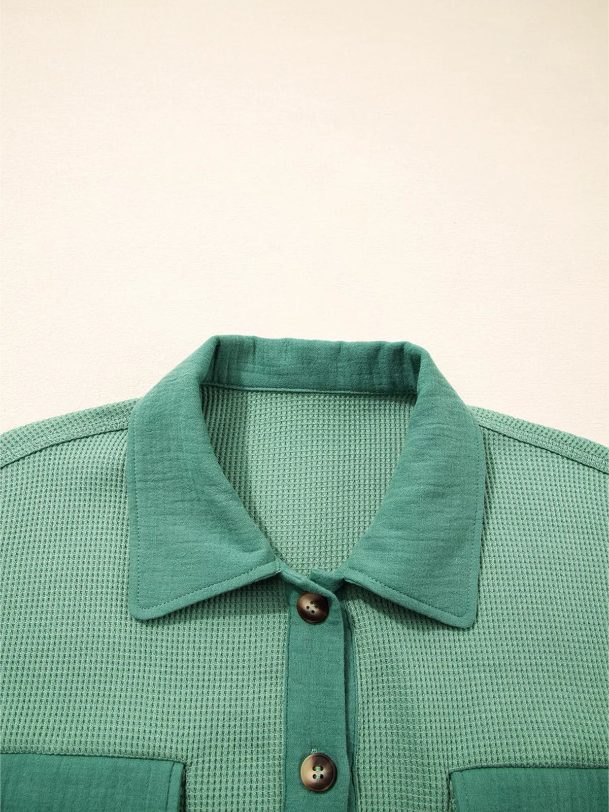Close-up of pointed collar and top button on sage shirt