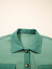 Close-up of pointed collar and top button on sage shirt