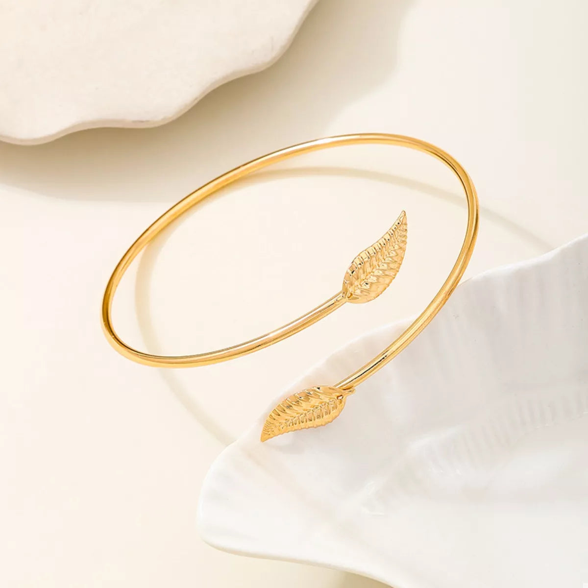 Gold-tone leaf open cuff bracelet shown in side view