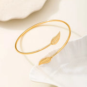 Gold-tone leaf open cuff bracelet shown in side view
