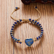 Navy beaded heart bracelet laid flat on wood with the adjustable cords extended.