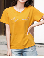 Model in a yellow T-shirt with white embroidered script across the chest