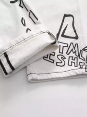 Close-up of folded hem and black print on white jeans