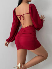 Back view showing the burgundy dress's open back and thin tie straps