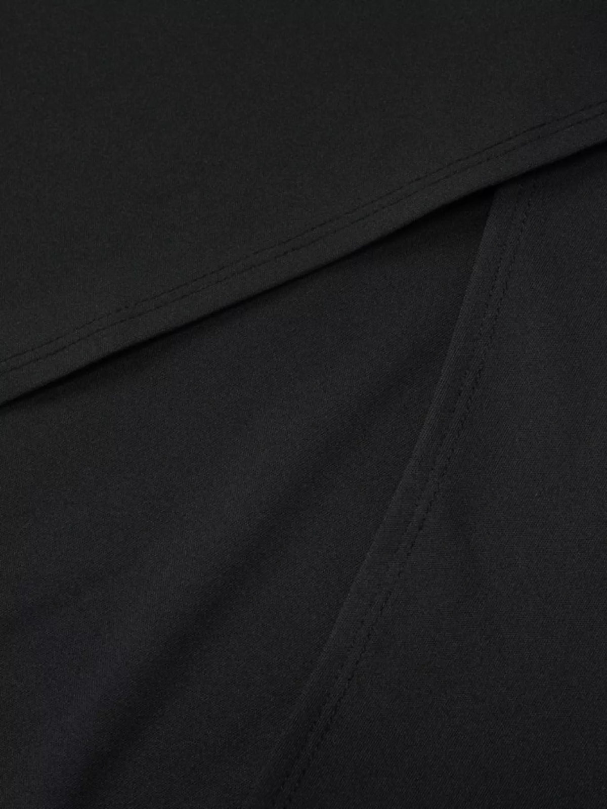 Detail view of the black maxi dress fabric and gathered seam.
