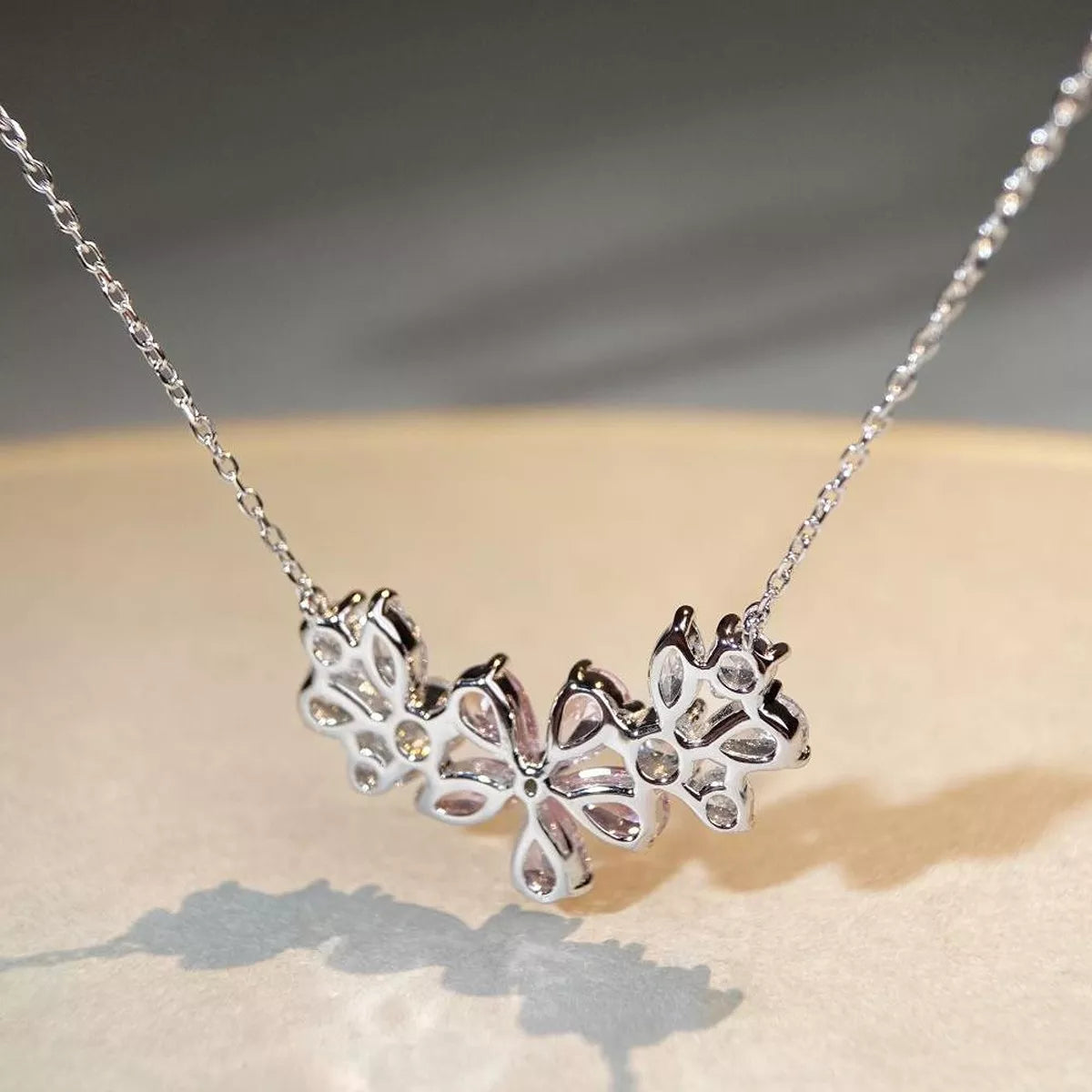 Close-up of silver-tone flower pendant necklace with clear stones