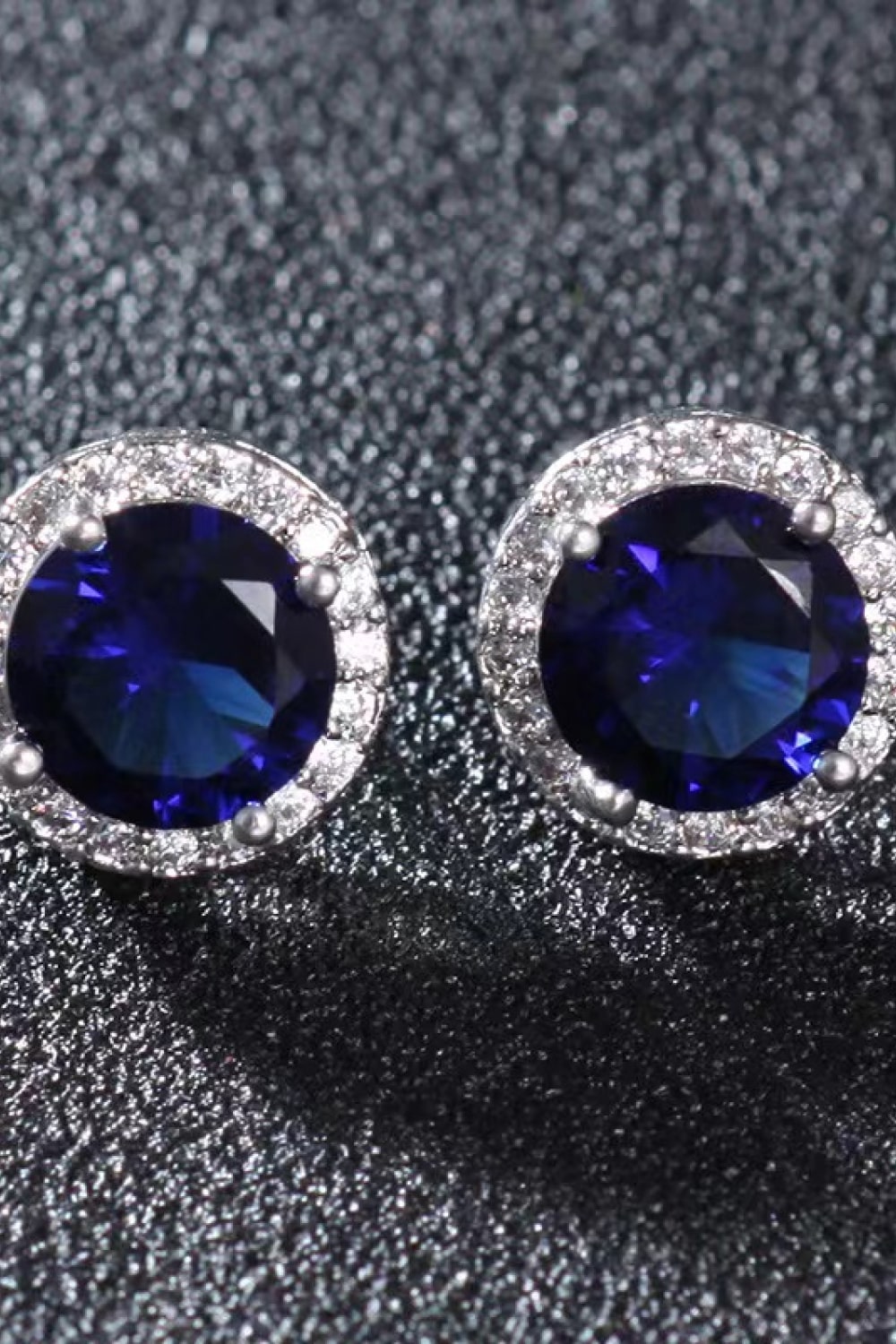 Contrast 2 Carat Moissanite Platinum-Plated Stud Earrings — Close-up of blue round moissanite studs on dark display