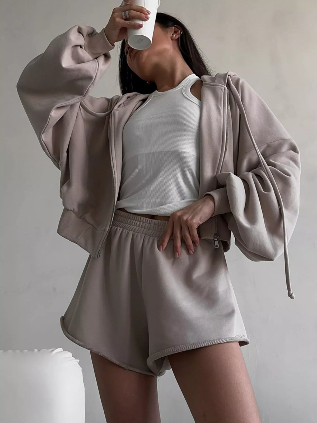 Model wearing olive zip hoodie and matching shorts