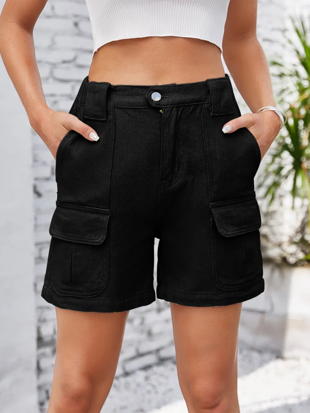 Angled front view of black shorts with flap cargo pockets.