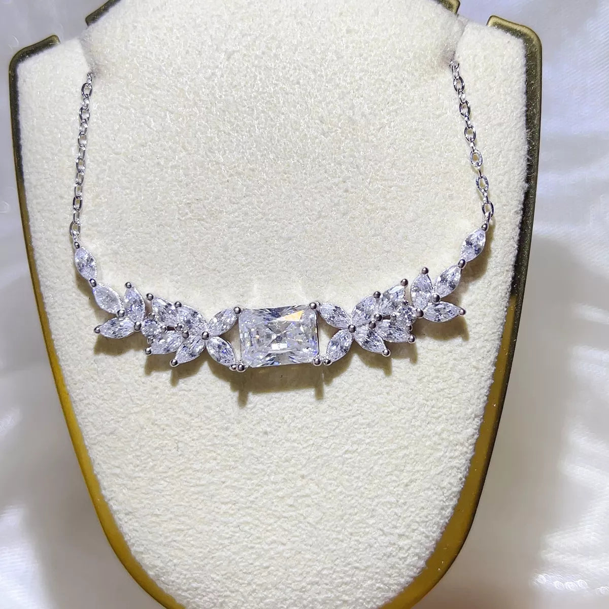 2 carat moissanite necklace with a floral cluster pendant on display